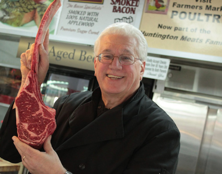 Huntington Meats Owner Jim Cascone holds up large cut of meat